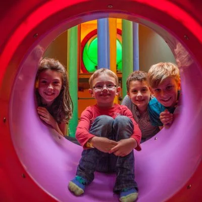 Children sat at the top of a tube slide at Rand Farm Park - Half Term Fun