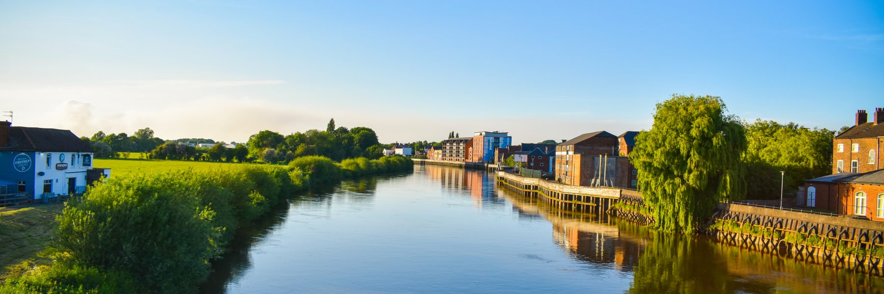 A summer view of the River Trent with a reflection of the riverside in the water.