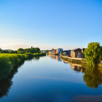 A summer view of the River Trent with a reflection of the riverside in the water.