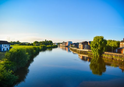 A summer view of the River Trent with a reflection of the riverside in the water.