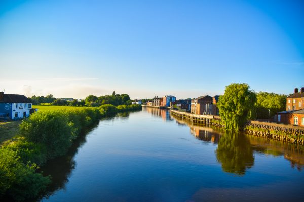 A summer view of the River Trent with a reflection of the riverside in the water.