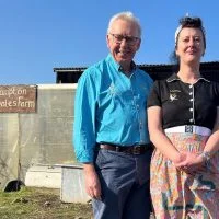 Hugh McDaniel and Loretta Adlam stood in front Brampton Dales Farm - Four in a Bed winner