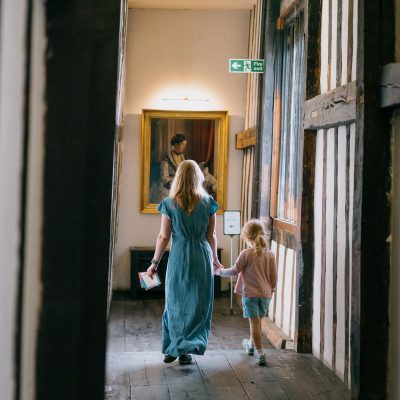 A woman and girl walking down the corridor at Gainsborough Old Hall.
