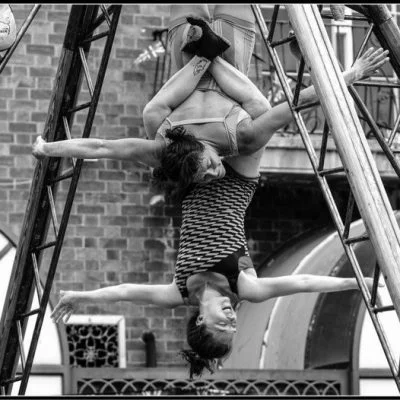 Two acrobats hanging from a pyramid structure at the Revive festival