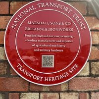 National Transport Trust Red Wheel plaque. Reads: Marshall Sons & Co Britannia Ironworks. Founded in 1848 and, for over a century, a leading manufacturer and exporter of agricultural machinery and military hardware.