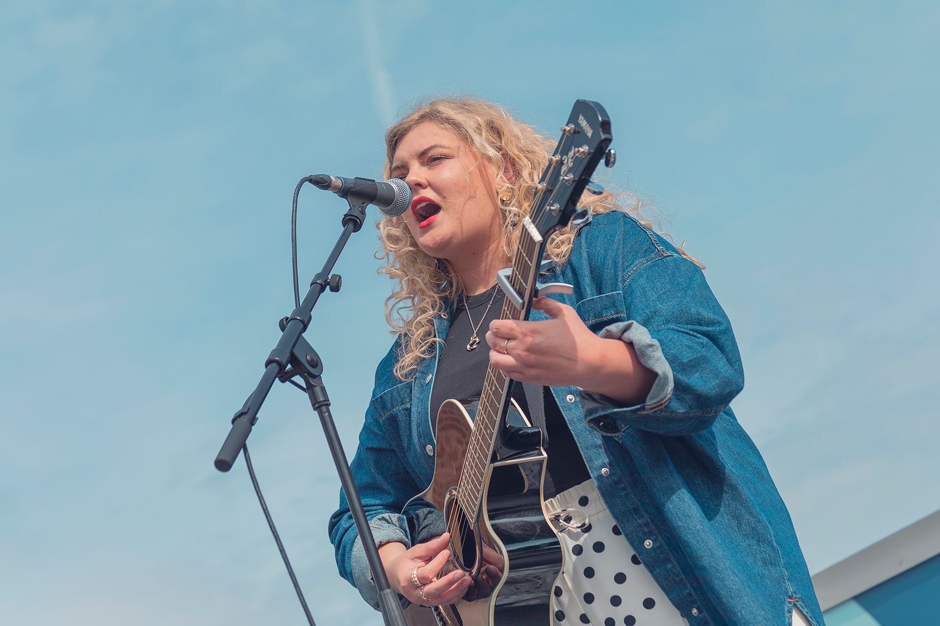 Lizzie Goddard singing and playing guitar at the Revive Festival