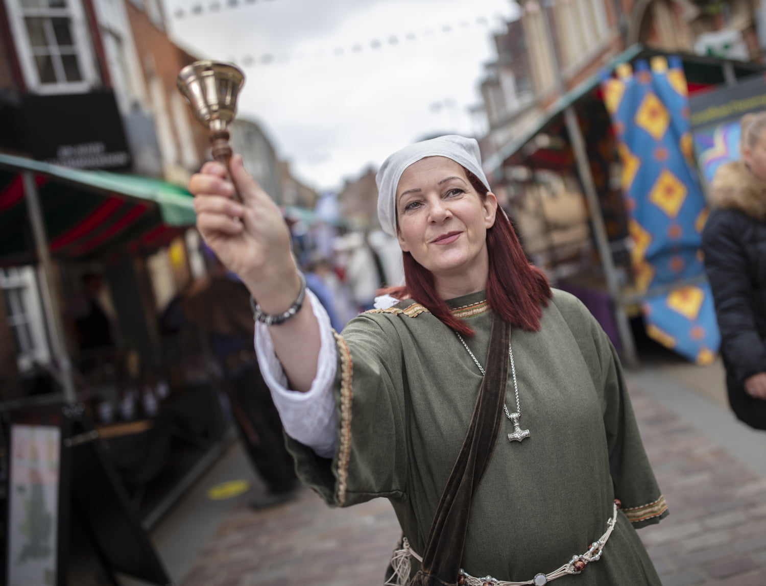 Woman in period costume ringing bell at the Merry Old Market
