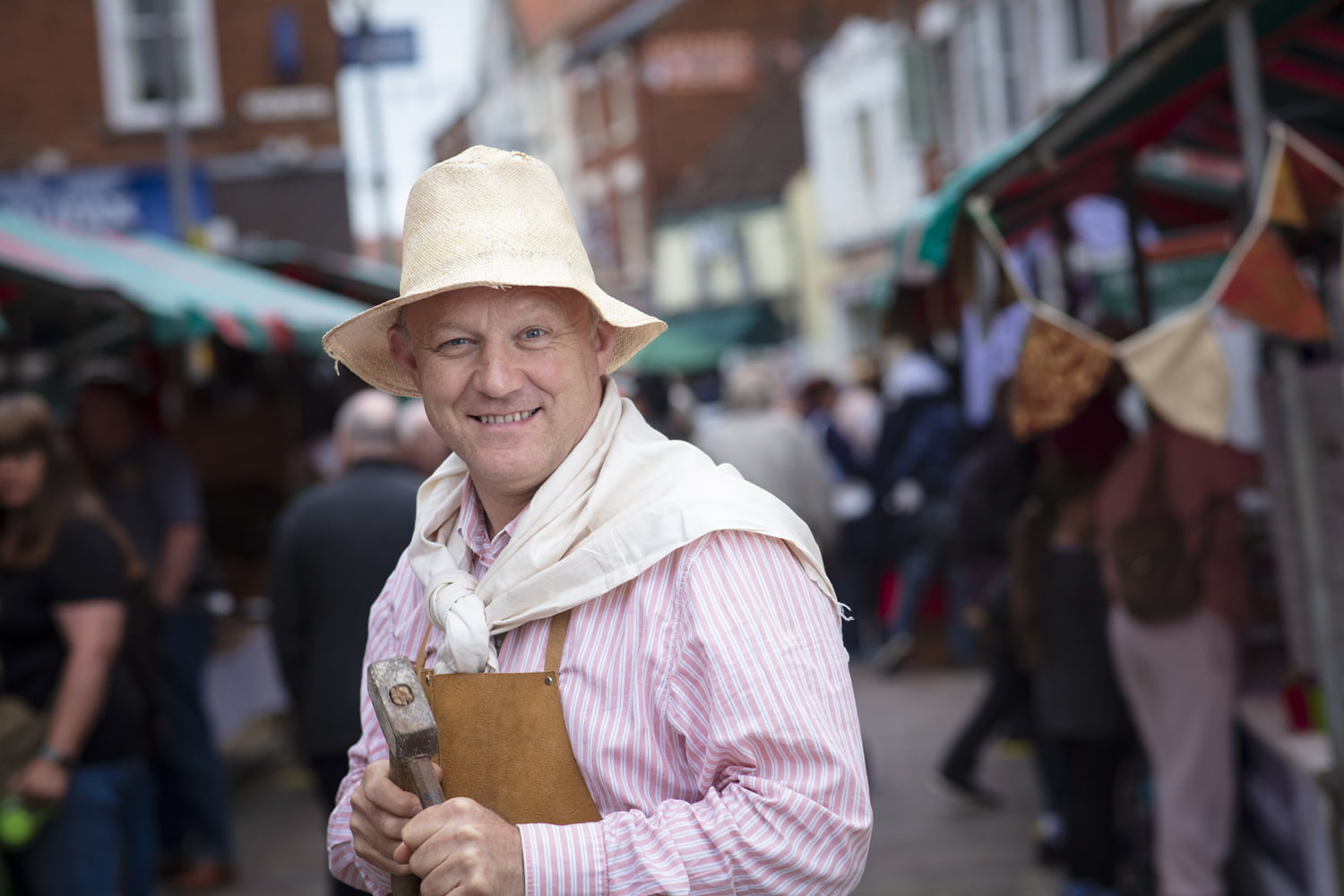 Jonathan in period costume with a hammer and chisel at the Merry Olde Market