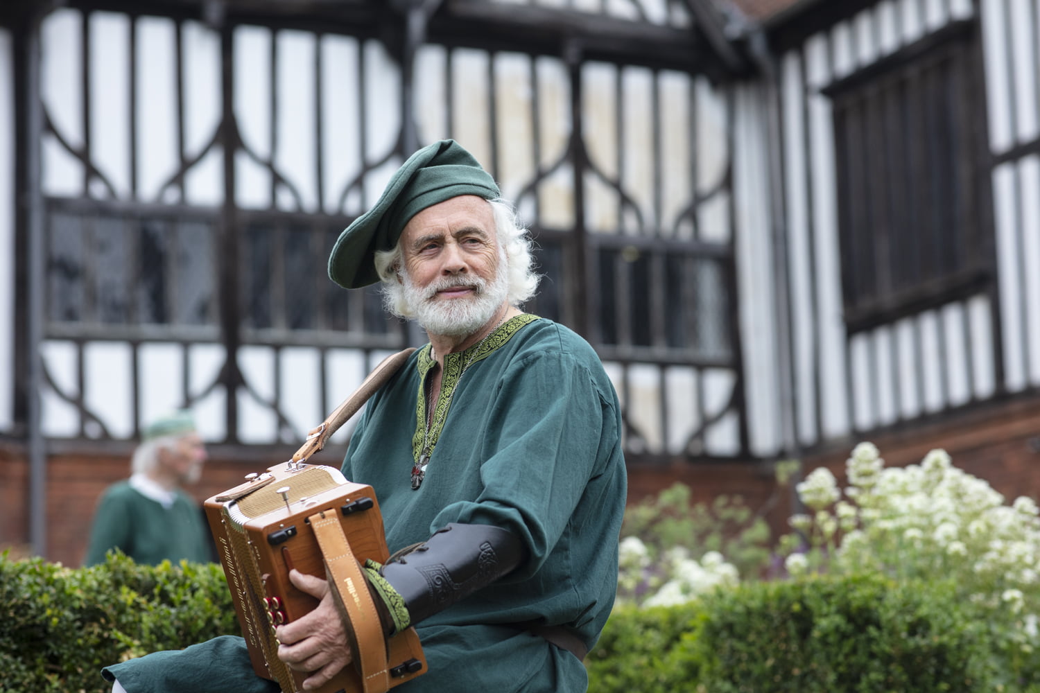 Man in period costume playing an accordion outside Gainsborough Old Hall