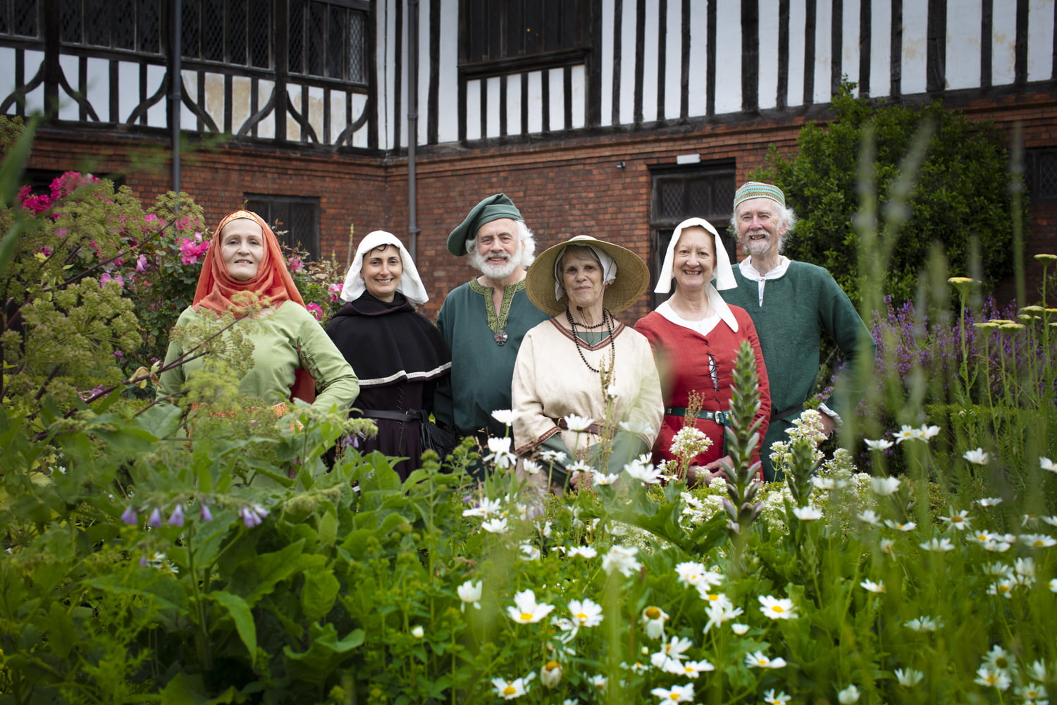 A group of people in period costume stood in the gardens at Gainsborough Old Halll