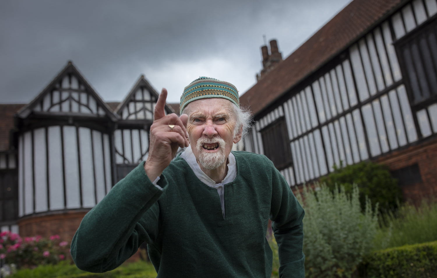 Man in period costume shaking finger at camera stood outside Gainsborough Old Hall