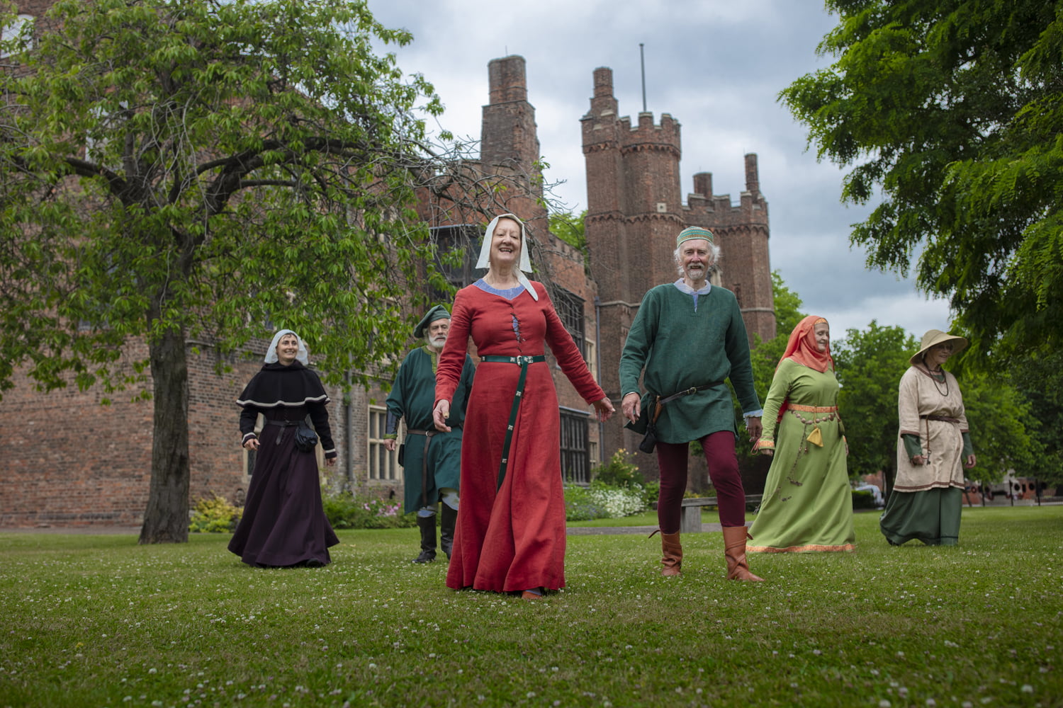 People in period costume walking across the grounds at Gainsborough Old Hall