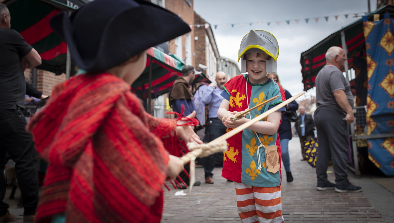 Two boys in sword fight in period costume