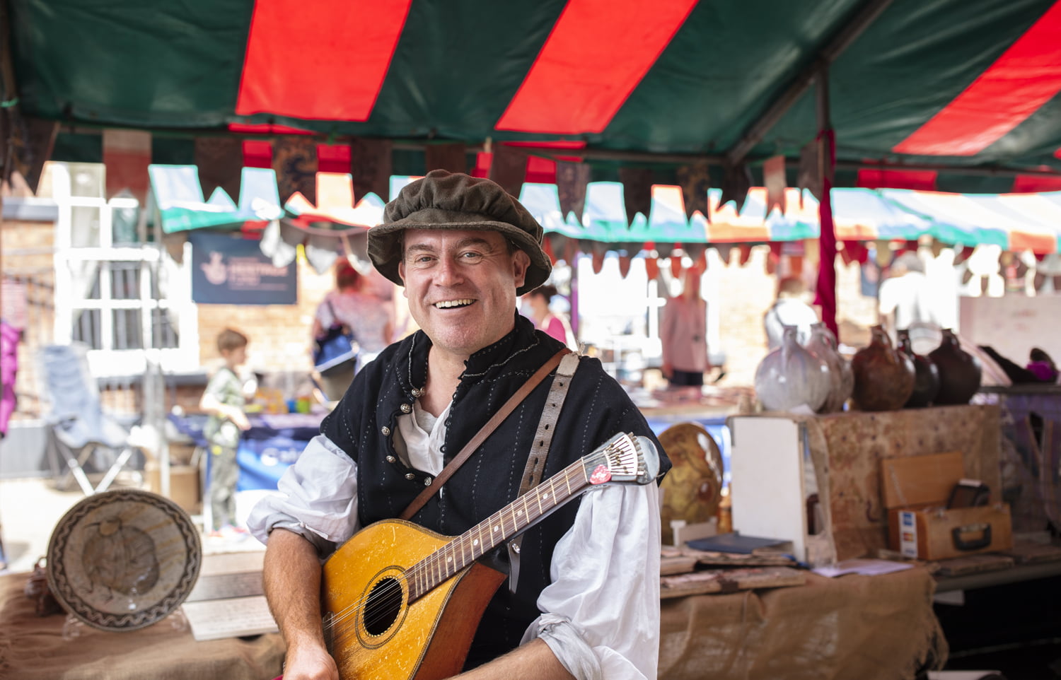 Man in period costume holding a guitar