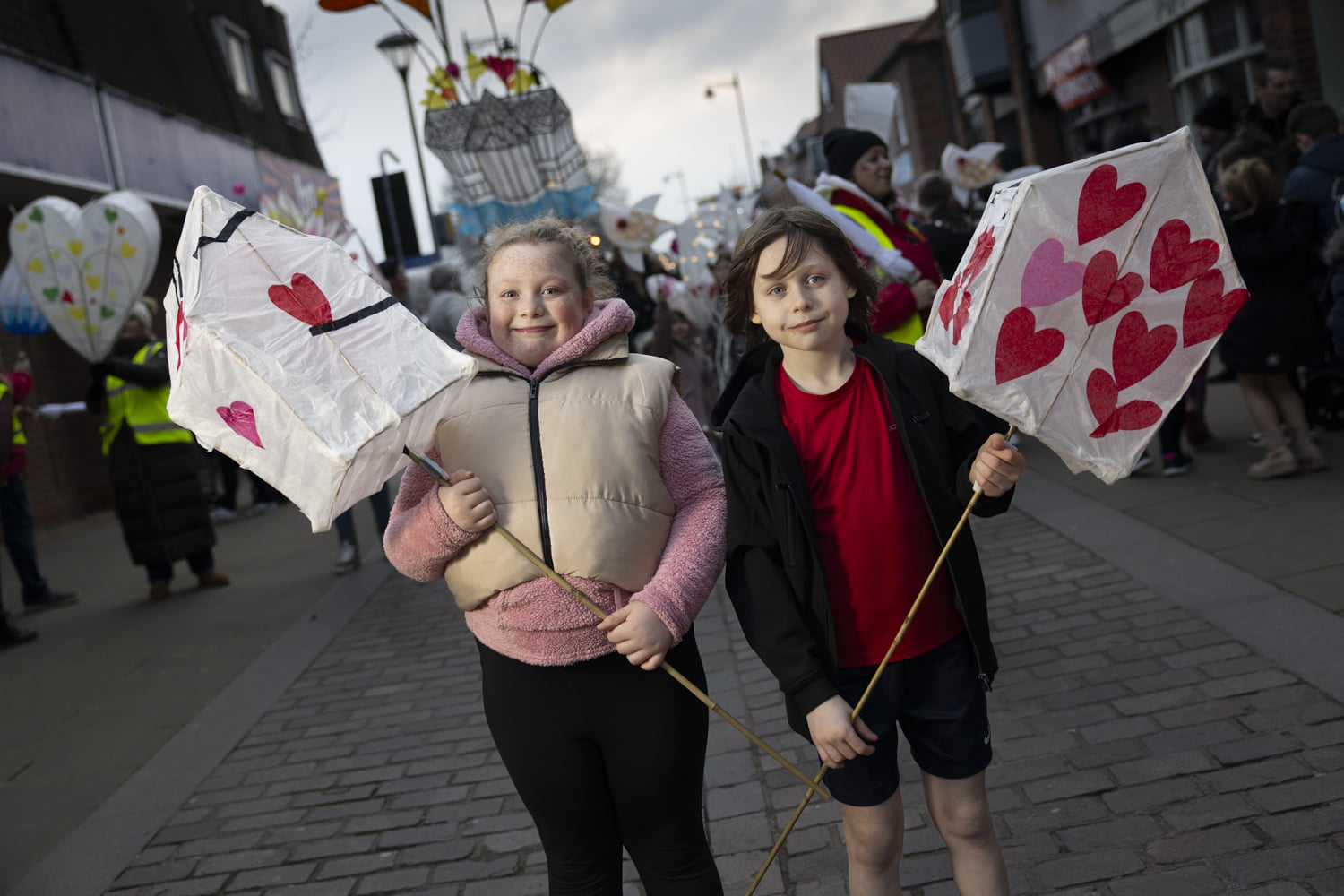 Two children holding large handmade lanterns