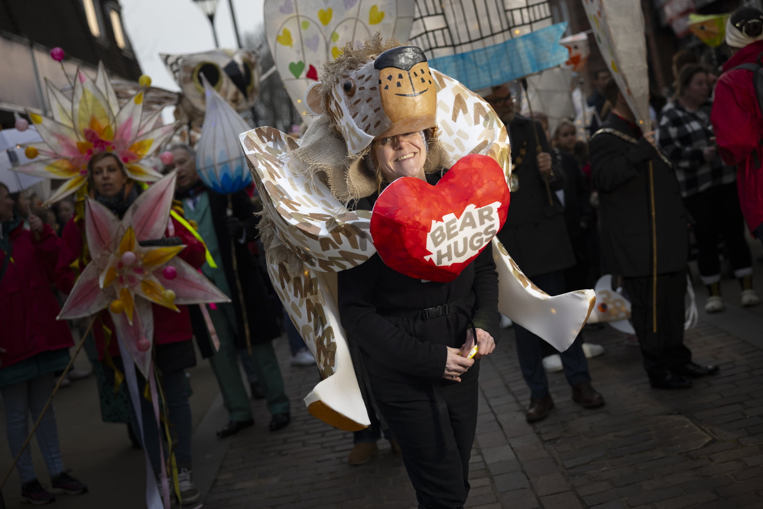 A large bear costume with a heart on the front saying &#039;Bear Hugs&#039;.