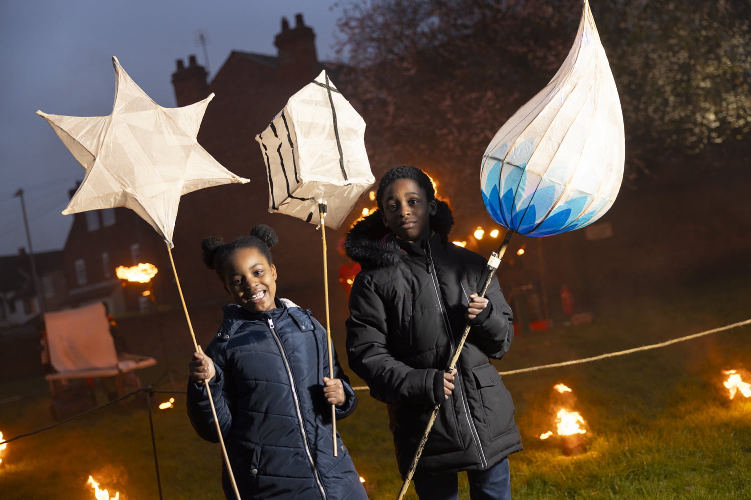 Visitors with large lanterns in the Fire Garden at Illuminate 2024