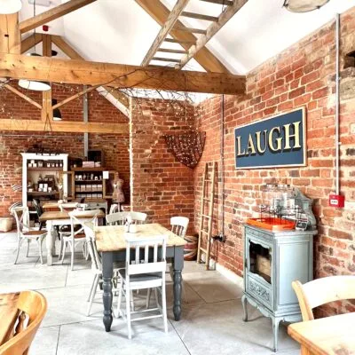 Interior of the cafe showing the development of an old barn with table and chairs where customer sit